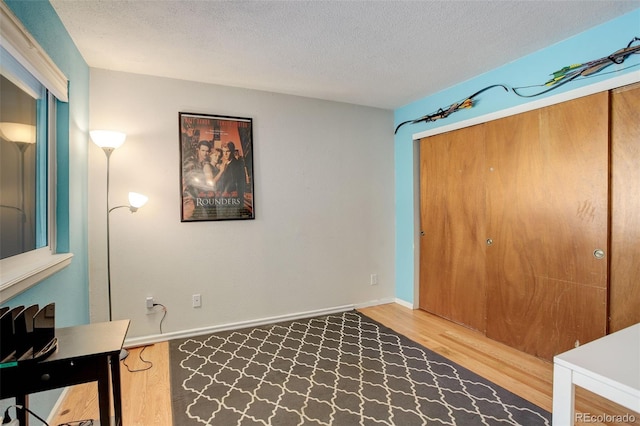 home office with wood finished floors, baseboards, and a textured ceiling