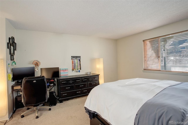 bedroom with a textured ceiling and light carpet