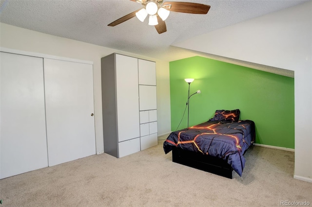 carpeted bedroom with a ceiling fan and a textured ceiling