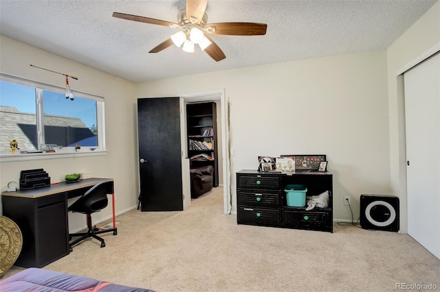 carpeted bedroom with a closet, baseboards, a textured ceiling, and ceiling fan