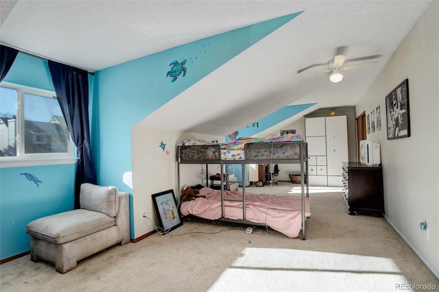 carpeted bedroom with a textured ceiling, lofted ceiling, baseboards, and a ceiling fan