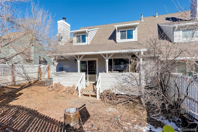 back of house featuring a shingled roof, a porch, fence private yard, and a chimney