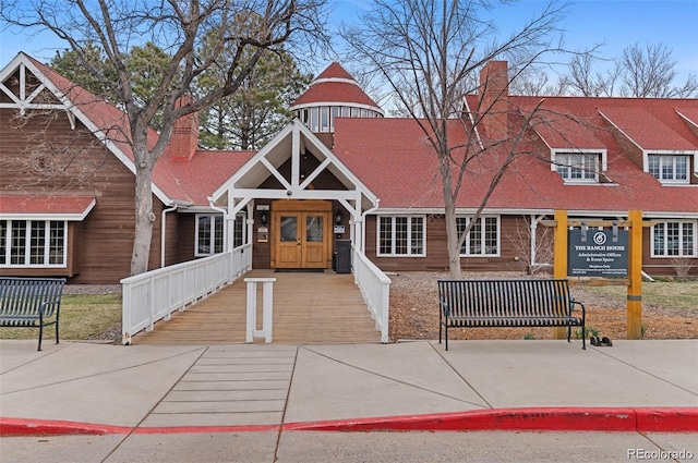 view of front of property with a chimney and a shingled roof