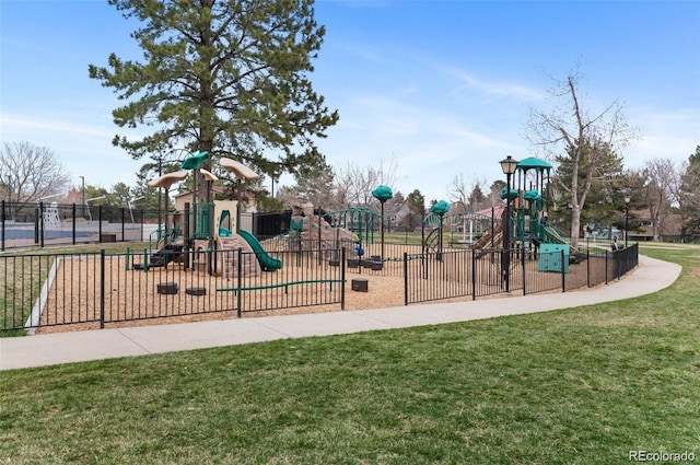 communal playground featuring a lawn and fence