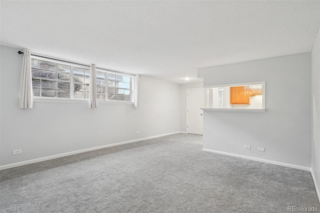 carpeted empty room featuring a textured ceiling