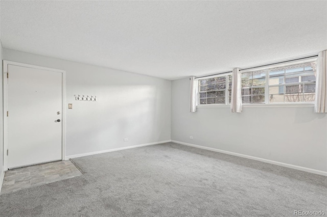 carpeted spare room with a textured ceiling