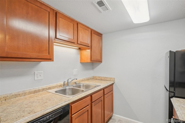 kitchen featuring stainless steel fridge, sink, dishwasher, and a textured ceiling