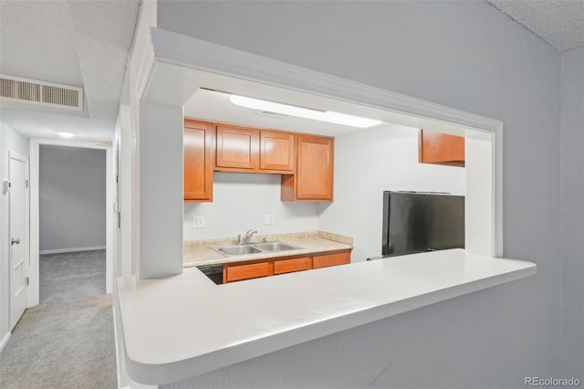 kitchen with light carpet, refrigerator, sink, a textured ceiling, and black dishwasher