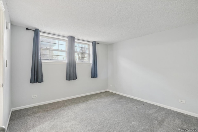 unfurnished room with carpet and a textured ceiling