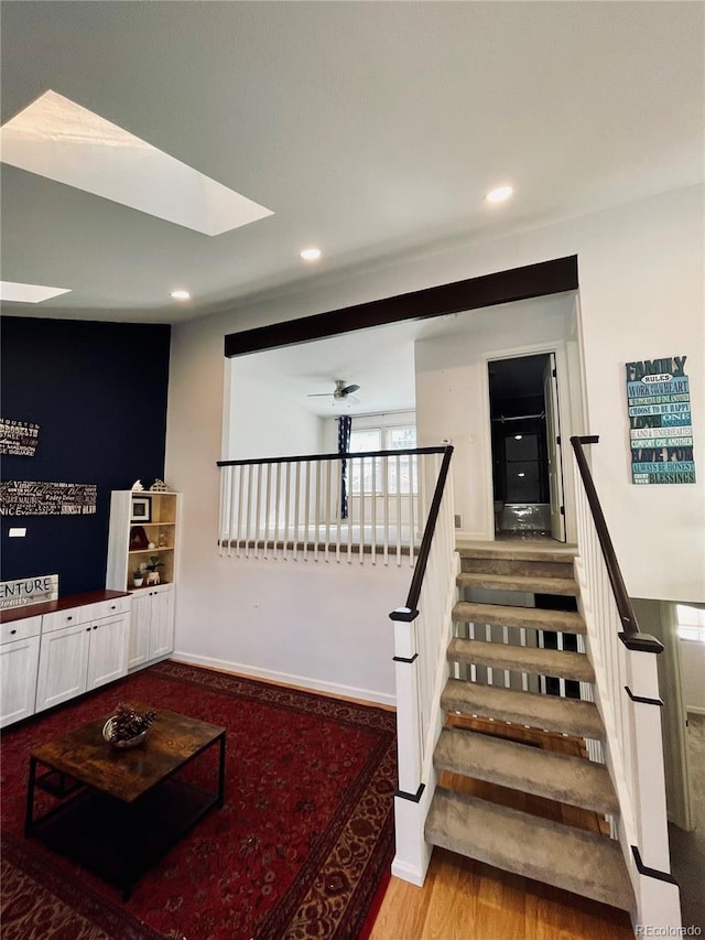 stairway with baseboards, wood finished floors, a ceiling fan, and recessed lighting