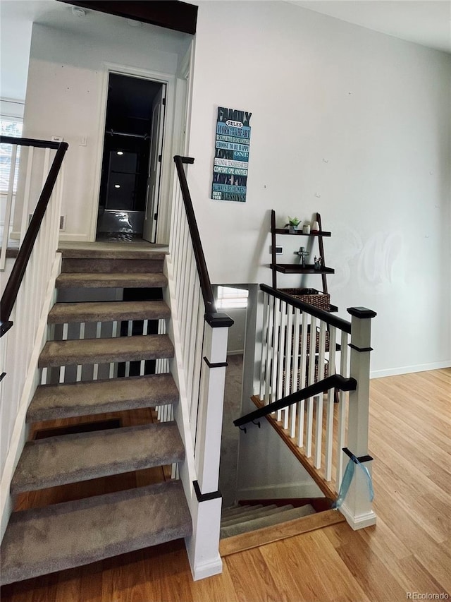 stairway featuring wood finished floors and baseboards