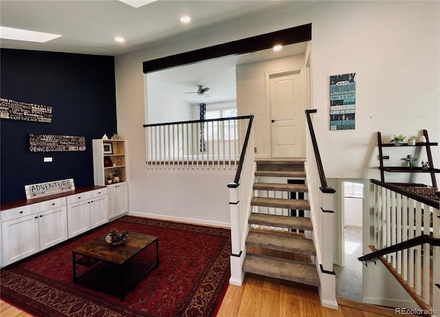 stairs with ceiling fan, baseboards, wood finished floors, and recessed lighting