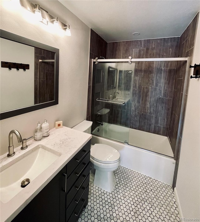 full bath featuring shower / bath combination with glass door, tile patterned flooring, vanity, and toilet