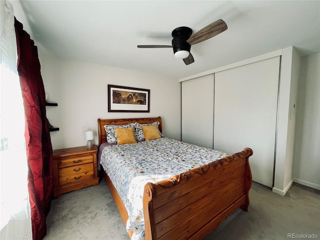 carpeted bedroom featuring ceiling fan and a closet