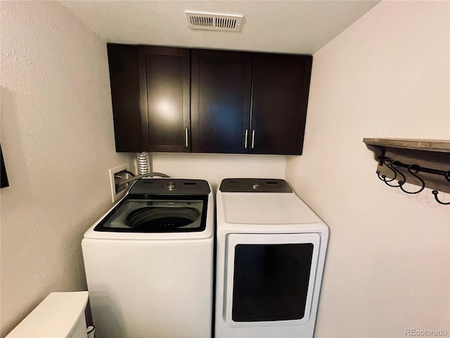 laundry area featuring cabinet space, visible vents, and separate washer and dryer