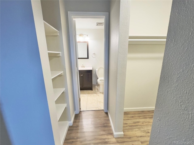 2325 S Linden Ct Unit 211, Denver, CO 80222 - walk in closet with wood finished floors and a sink