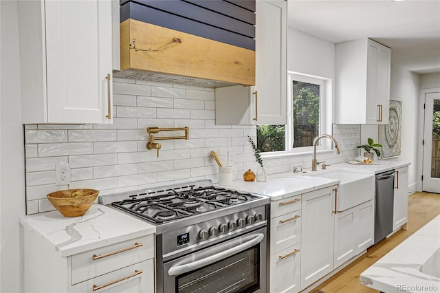 kitchen with backsplash, light stone countertops, appliances with stainless steel finishes, and white cabinets