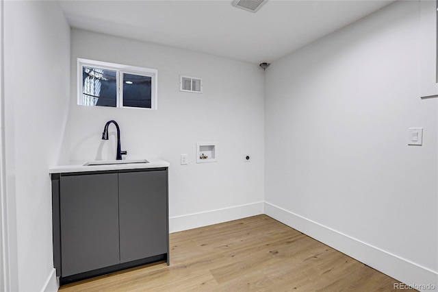 washroom featuring hookup for an electric dryer, light wood-type flooring, hookup for a washing machine, cabinets, and sink