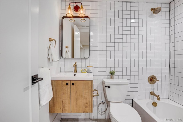 full bathroom with toilet, vanity, tile walls, and tiled shower / bath