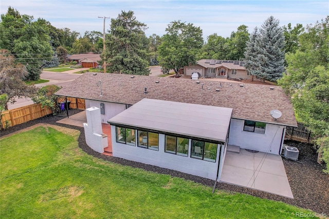 rear view of house with a lawn and central AC unit