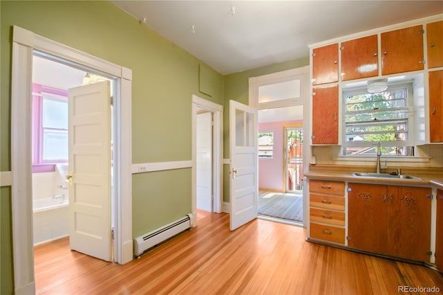 kitchen featuring a baseboard heating unit, light wood-type flooring, and sink