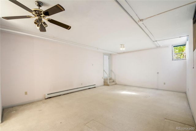 basement with ceiling fan, light colored carpet, and a baseboard heating unit