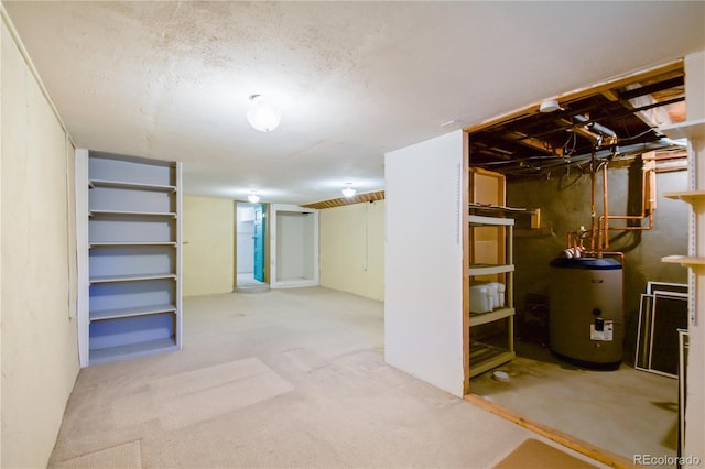 basement with light colored carpet, water heater, and a textured ceiling