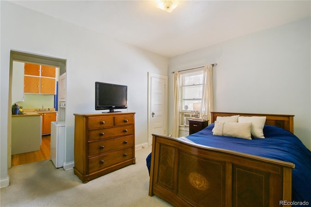 bedroom with light colored carpet and sink