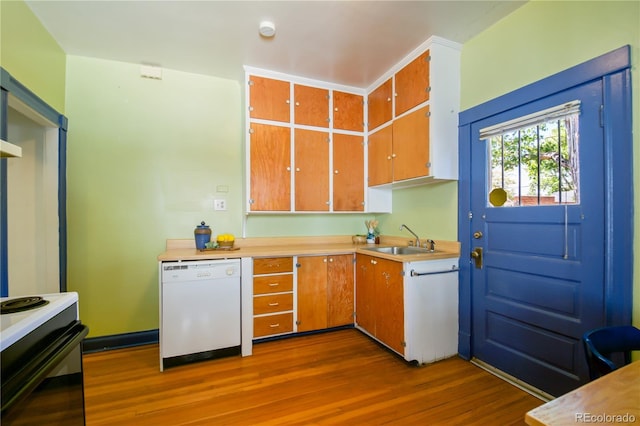 kitchen with light wood-type flooring, sink, and white appliances