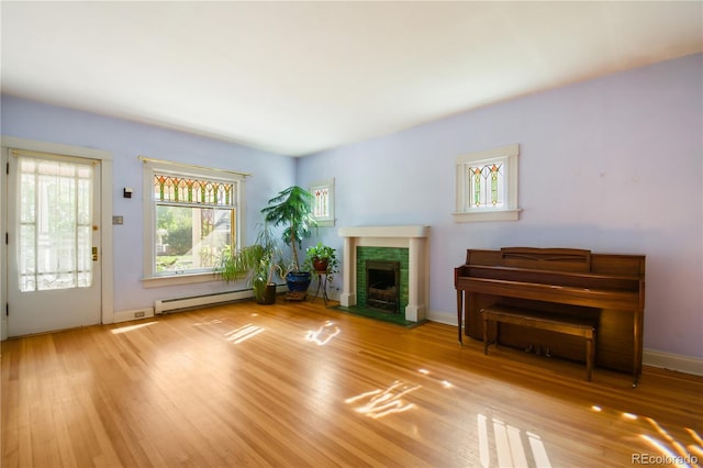 unfurnished living room featuring a baseboard heating unit and light wood-type flooring