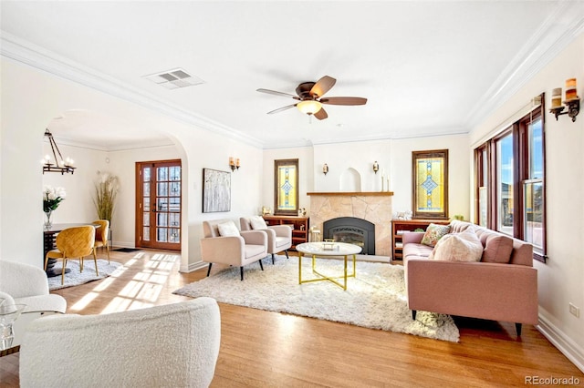 living area with a wealth of natural light, arched walkways, visible vents, and light wood finished floors