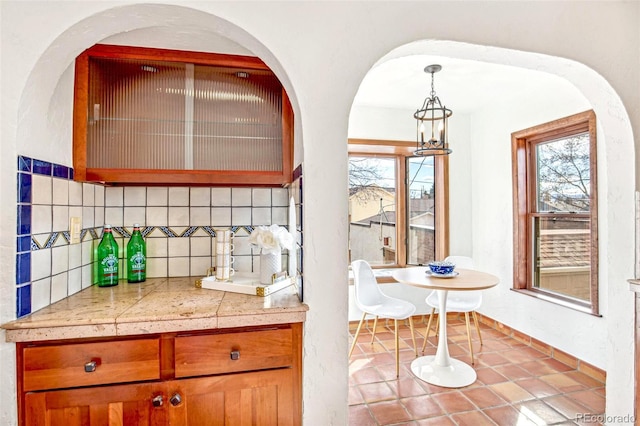 kitchen with tile counters, a wealth of natural light, decorative light fixtures, and backsplash