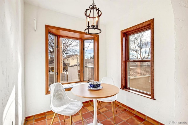 dining area featuring an inviting chandelier, baseboards, and a wealth of natural light