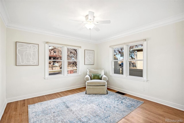 sitting room featuring ceiling fan, crown molding, baseboards, and wood finished floors