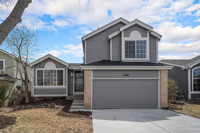 view of front of home featuring roof with shingles, a garage, concrete driveway, and brick siding