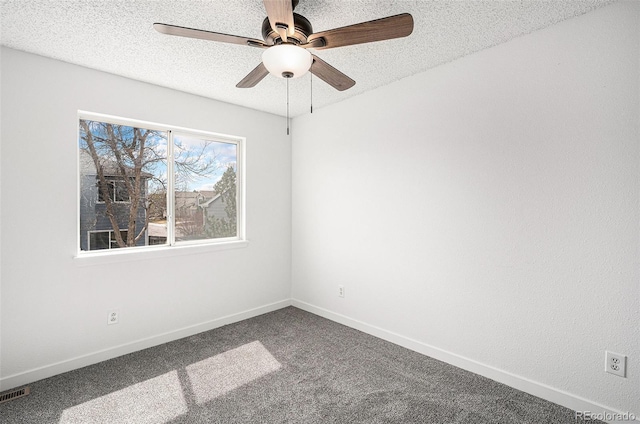carpeted spare room featuring a textured ceiling, baseboards, a ceiling fan, and visible vents