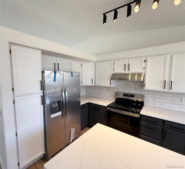 kitchen with light countertops, backsplash, white cabinets, under cabinet range hood, and stainless steel appliances