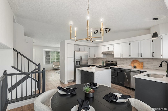 5068 E Crestone Ave, Castle Rock, CO 80104 - kitchen with stainless steel appliances, a sink, backsplash, light countertops, and a textured ceiling