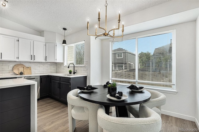 5068 E Crestone Ave, Castle Rock, CO 80104 - kitchen with a sink, backsplash, a textured ceiling, a chandelier, and light countertops