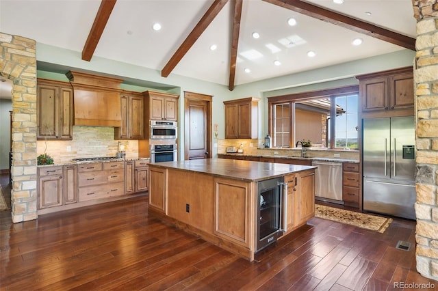 2480 Castle Butte Dr, Castle Rock, CO 80109 - kitchen with vaulted ceiling with beams, stainless steel appliances, wine cooler, custom range hood, and a center island