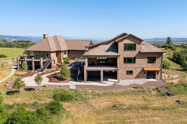 2480 Castle Butte Dr, Castle Rock, CO 80109 - view of front of property with stairs, stucco siding, a chimney, a balcony, and stone siding