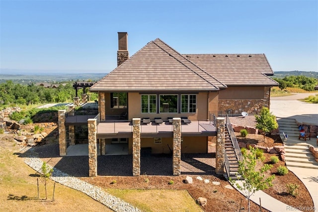 2480 Castle Butte Dr, Castle Rock, CO 80109 - view of front facade with a patio, stairway, a chimney, and stucco siding