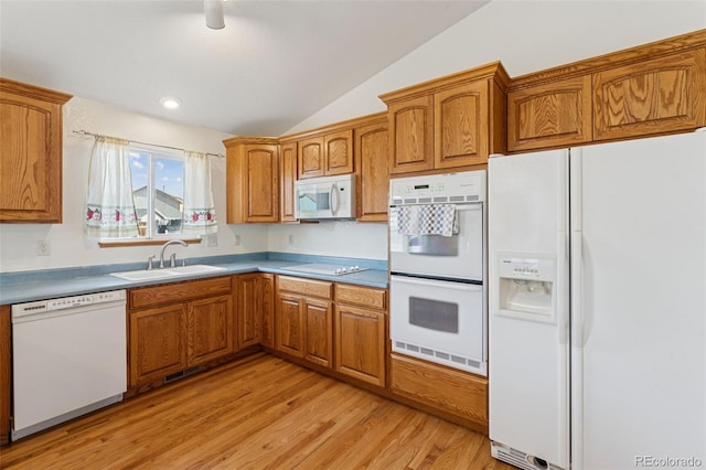 kitchen with white appliances, brown cabinets, and a sink