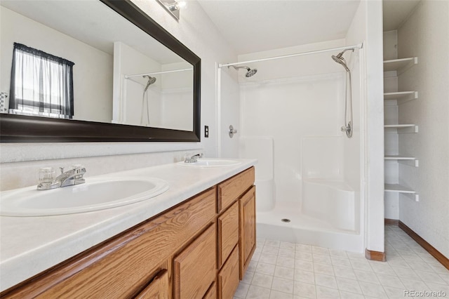 bathroom with double vanity, walk in shower, and a sink