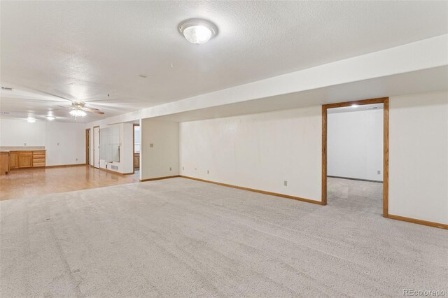 interior space with light carpet, a textured ceiling, visible vents, and baseboards