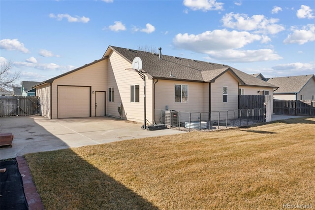 rear view of house featuring central AC unit, a garage, fence, concrete driveway, and a lawn