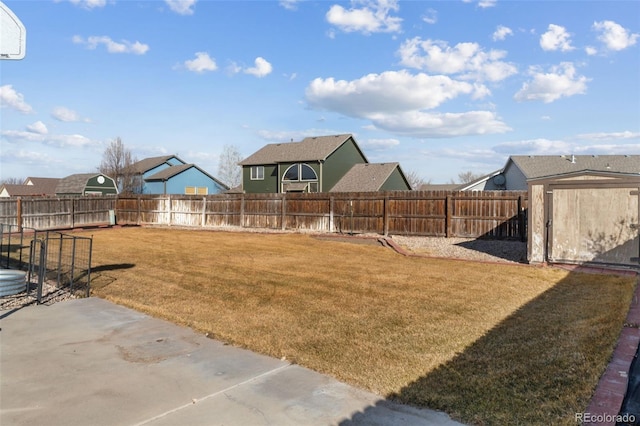 view of yard featuring an outbuilding, a patio, a storage unit, and a fenced backyard