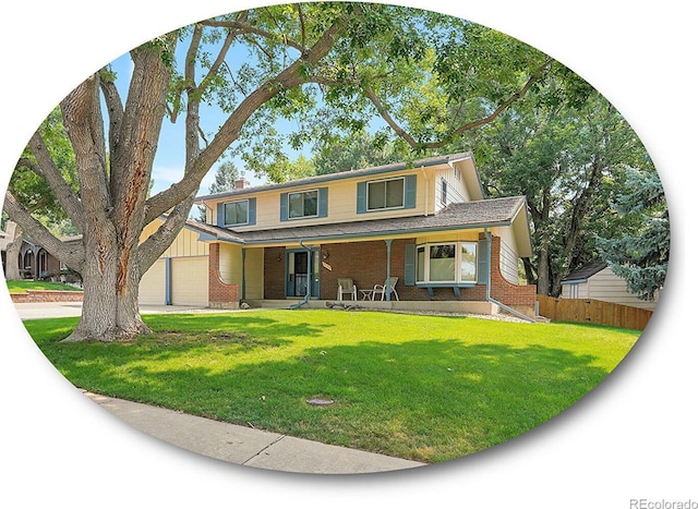 traditional-style house featuring a garage, covered porch, brick siding, fence, and a front yard