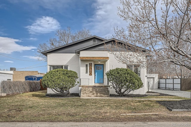 bungalow-style home featuring a front lawn and fence