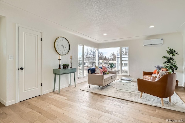 living room with baseboards, recessed lighting, light wood-style floors, a textured ceiling, and a wall mounted AC